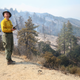 Elizabeth Wright with the Forest Service monitors a firefighting helicopter making water drops during the Bobcat Fire in the Angeles National Forest on Sept. 16, 2020 near Pasadena, California.